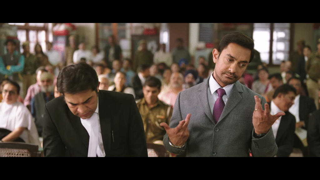 Aamir Khan comforting a young boy in a school art room scene from Sitaare Zameen Par.